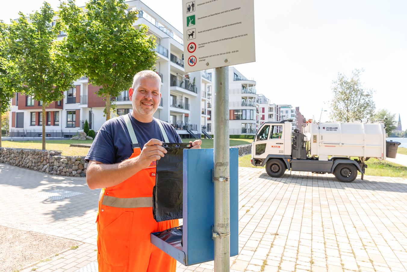 SAS-Mitarbeiter René Siegel füllt regelmäßig den Behälter am Ziegelsee mit schwarzen Hundekotbeuteln nach, Foto: maxpress/srk