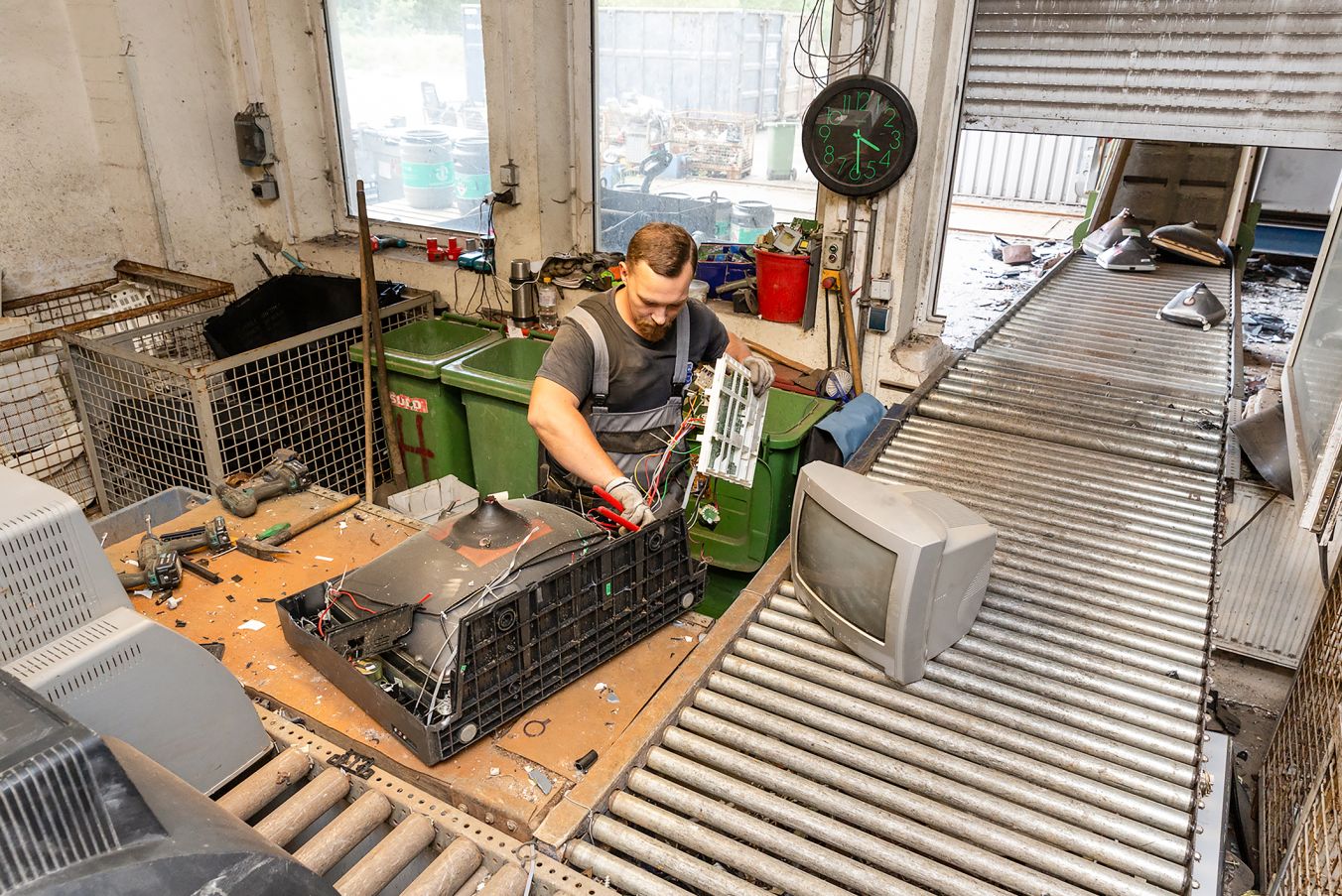 Mitarbeiter Heiko Schreiner demontiert alte Röhrenfernseher